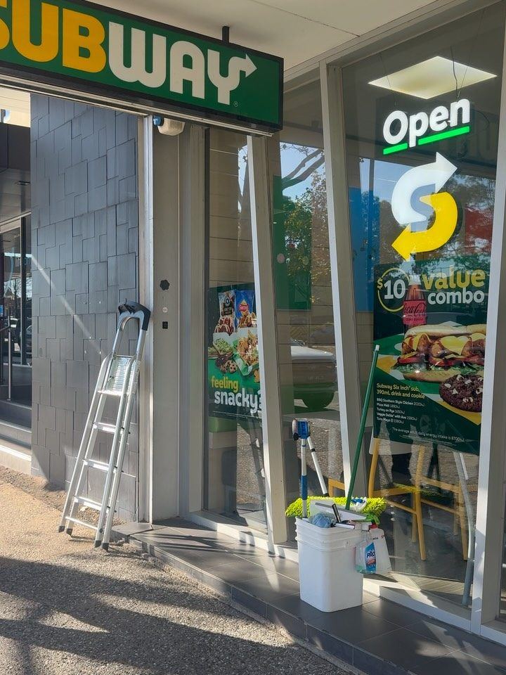 Subway shopfront being cleaned with ladder and squeegee kit